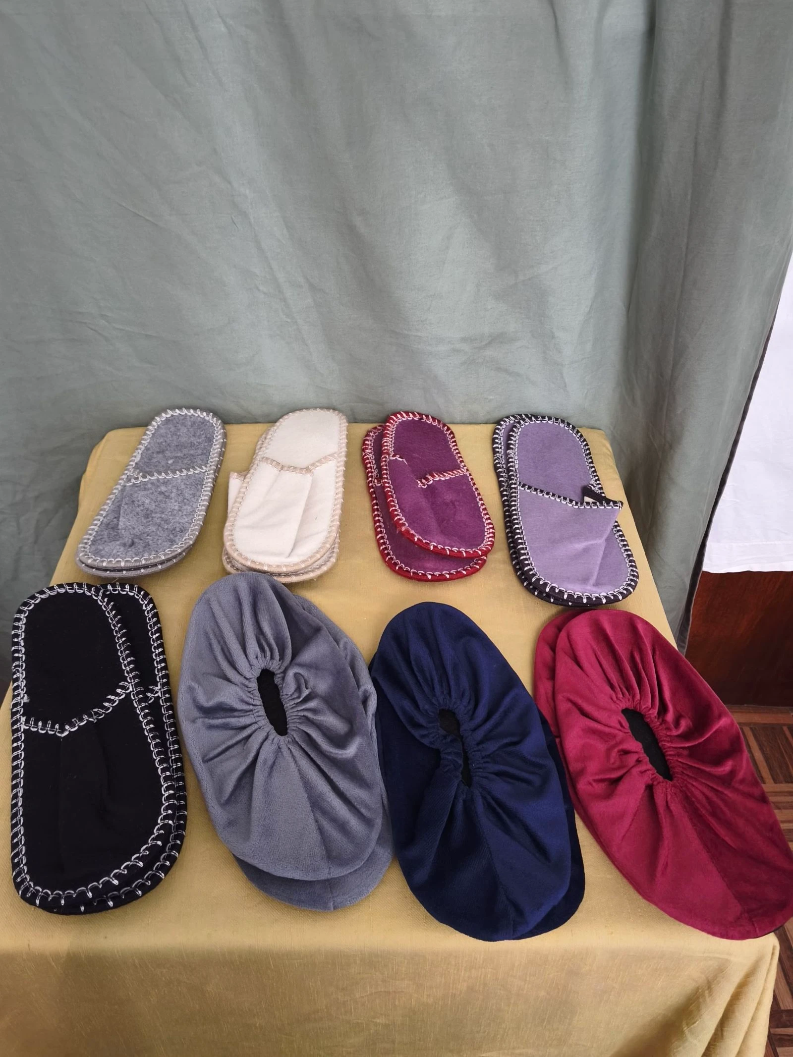 Conjunto de oito chinelos para visitas em diferentes cores e materiais.